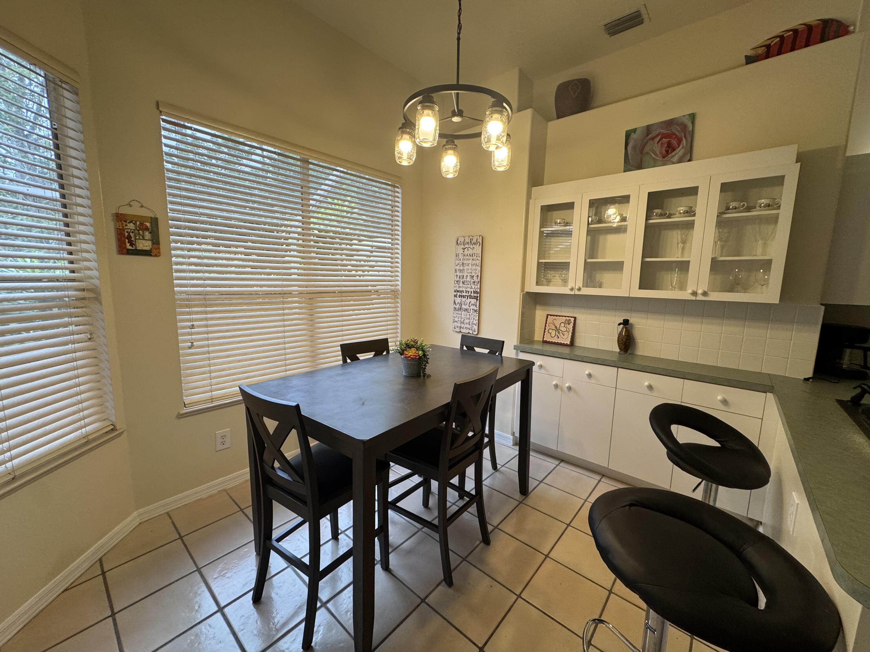 1872 Southwest Airoso Boulevard Port St. Lucie, FL 34984 - Photo 8 of 12 a view of a dining room with furniture and chandelier