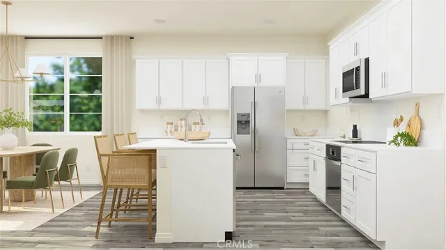 a kitchen with a refrigerator a stove top oven a sink dishwasher and white cabinets with wooden floor