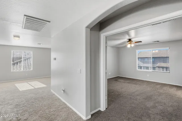 an empty room with closet and a chandelier fan