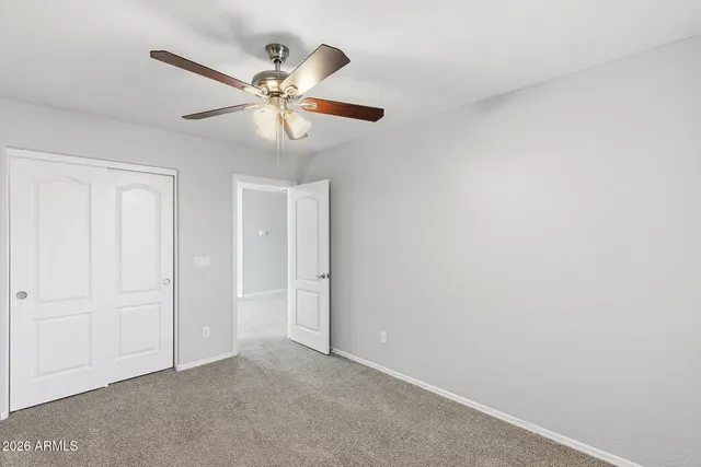 an empty room with a window and a fan