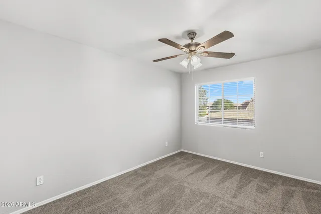 an empty room with a fan and a fan