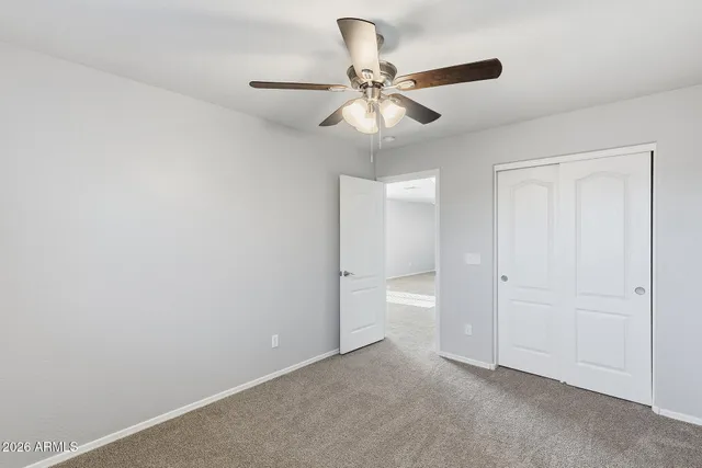 an empty room with a window and a fan