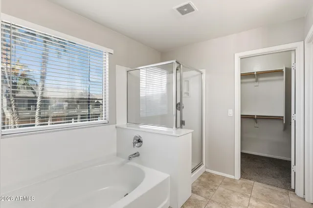 a spacious bathroom with a tub sink shower and mirror