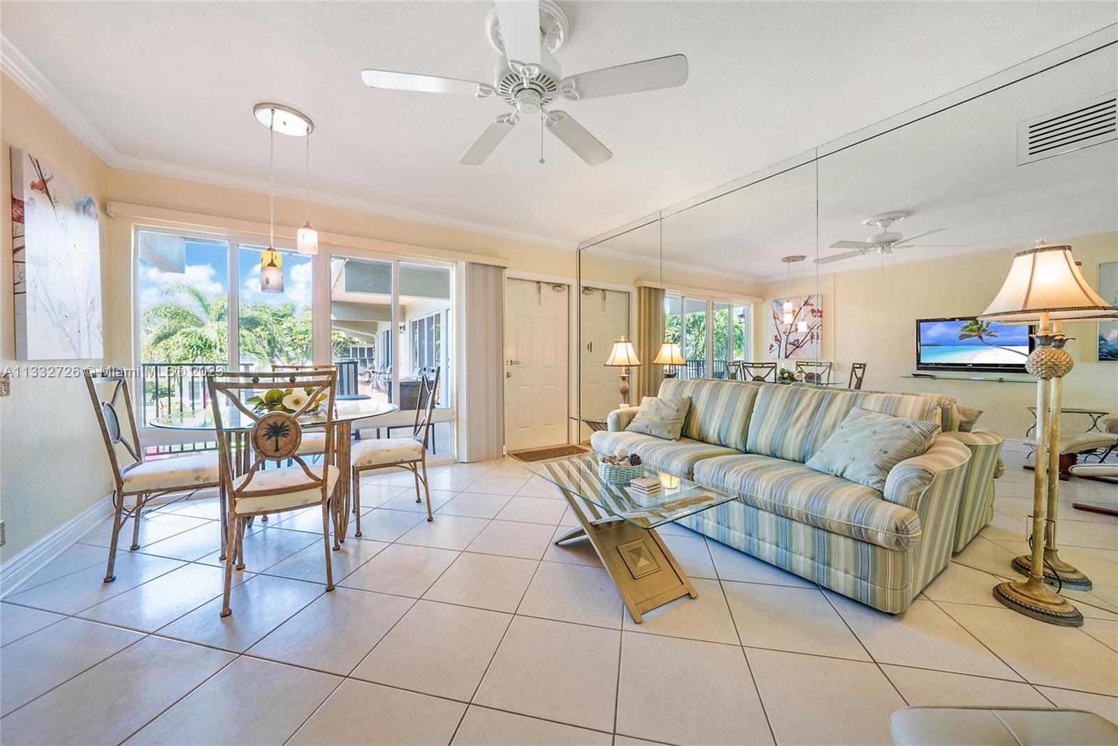 555 North Riverside Drive, Unit 15 Pompano Beach, FL 33062 - Photo 4 of 18 a living room with furniture a dining table and a floor to ceiling window