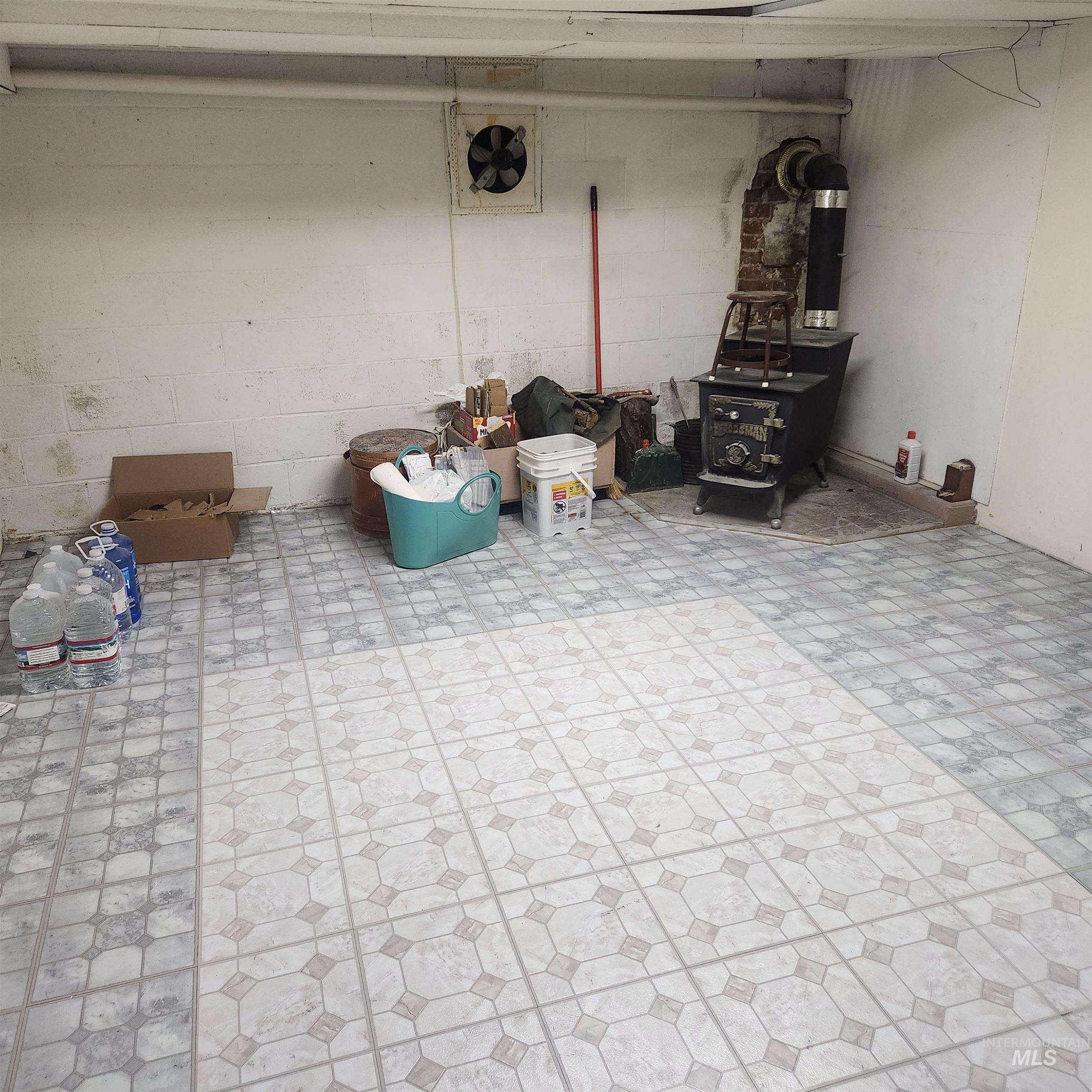 530 California Street Gooding, ID 83330 - Photo 22 of 30 Basement featuring a wood stove, concrete block wall, and light floors