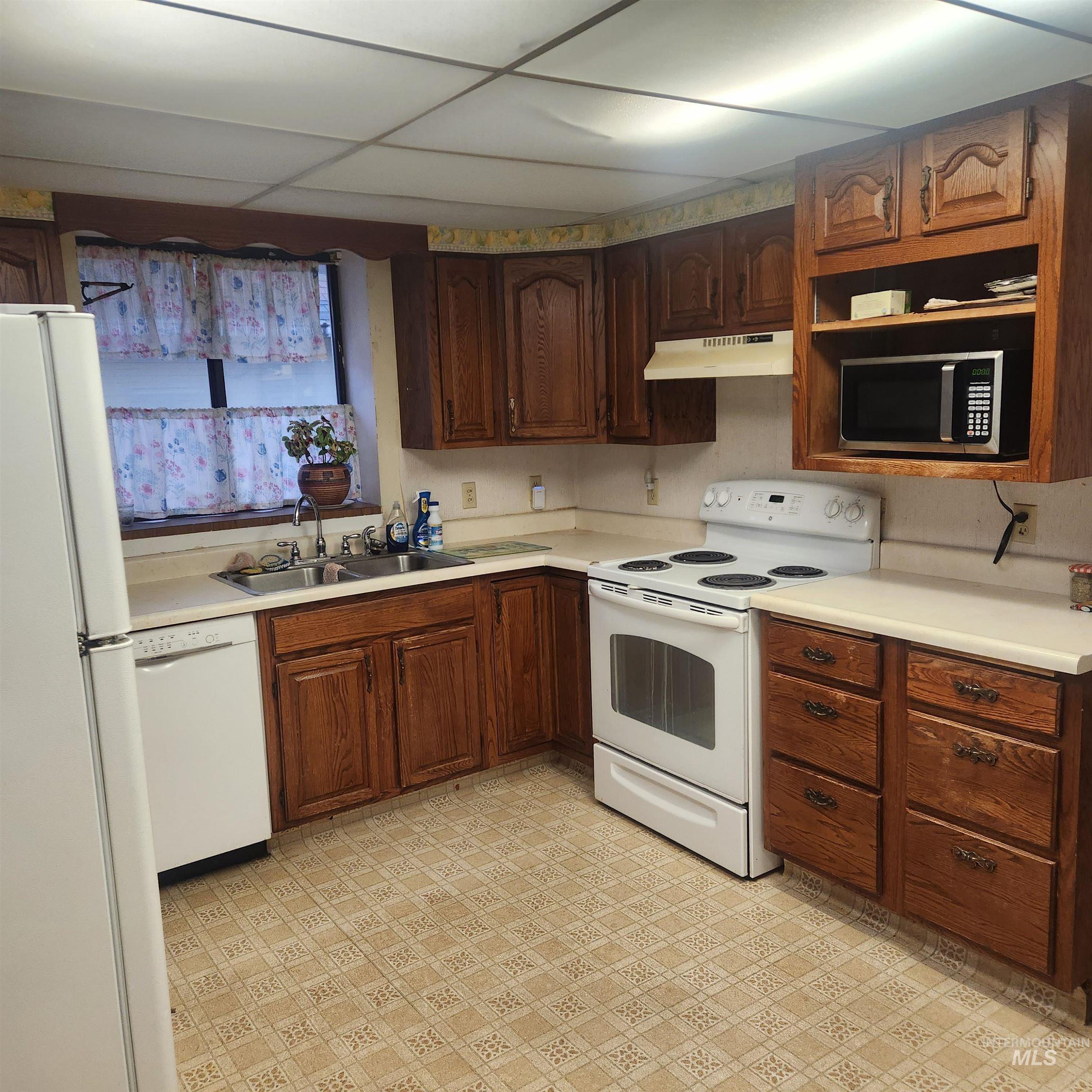 530 California Street Gooding, ID 83330 - Photo 7 of 30 Kitchen featuring white appliances, light countertops, light flooring, and a paneled ceiling
