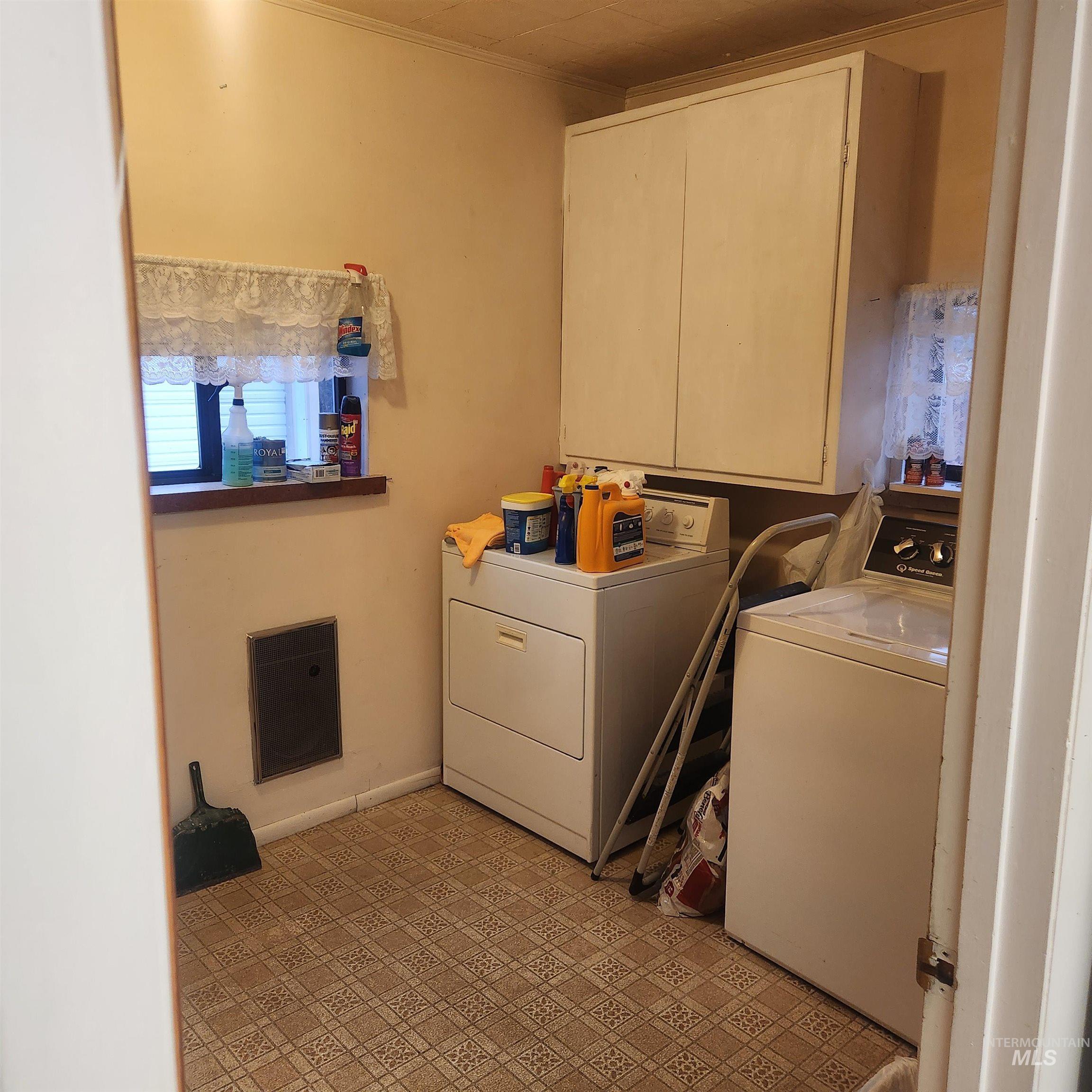 530 California Street Gooding, ID 83330 - Photo 8 of 30 Laundry area with light floors, cabinet space, washing machine and dryer, ornamental molding, and heating unit