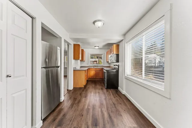 a view of hallway with wooden floor and a window