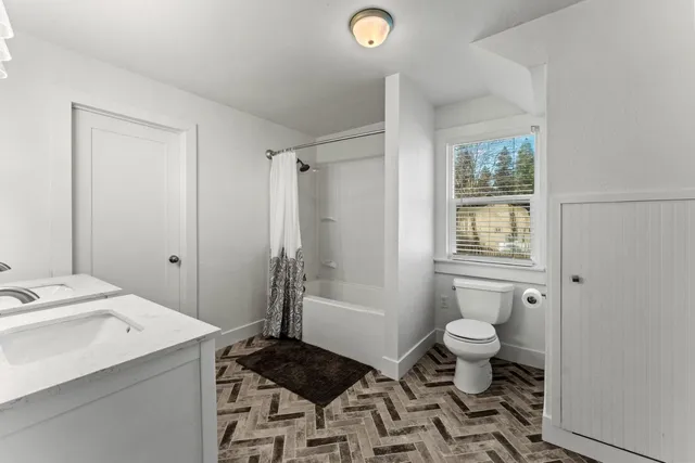 a bathroom with a granite countertop sink toilet and shower