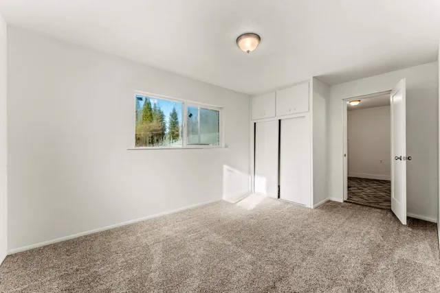 an empty room with windows and closet