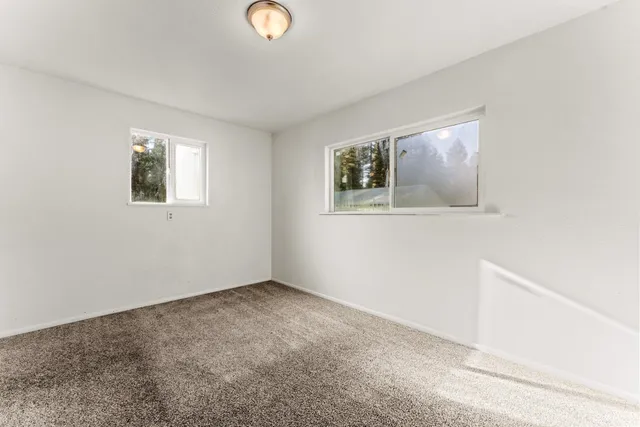 an empty room with wooden floor and window