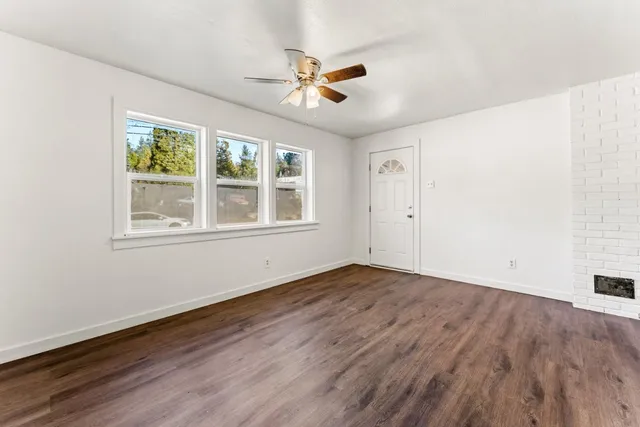 a view of a livingroom with wooden floor and a window