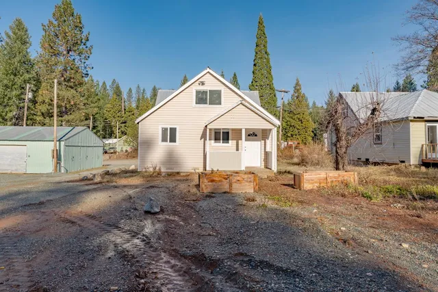 a view of a house with backyard and trees