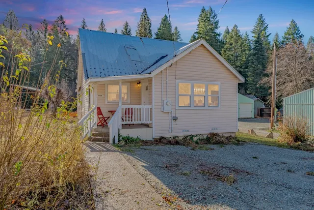 a view of a house with backyard and trees