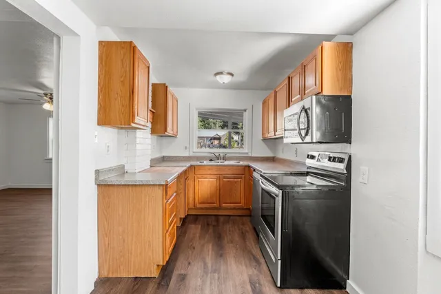 a kitchen with stainless steel appliances granite countertop a stove a sink and a refrigerator