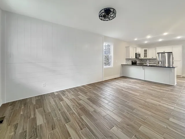 an empty room with a wooden floor and windows