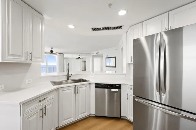 a kitchen with white cabinets stainless steel appliances and sink