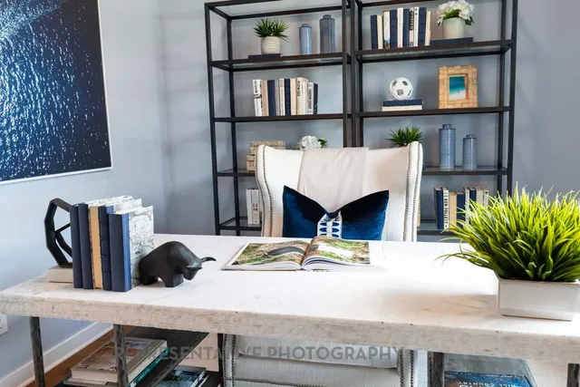 a workspace room with furniture and a potted plant
