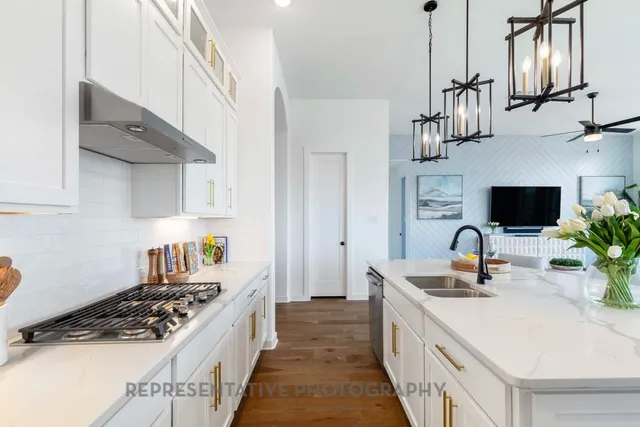 a kitchen with stainless steel appliances a sink stove and cabinets