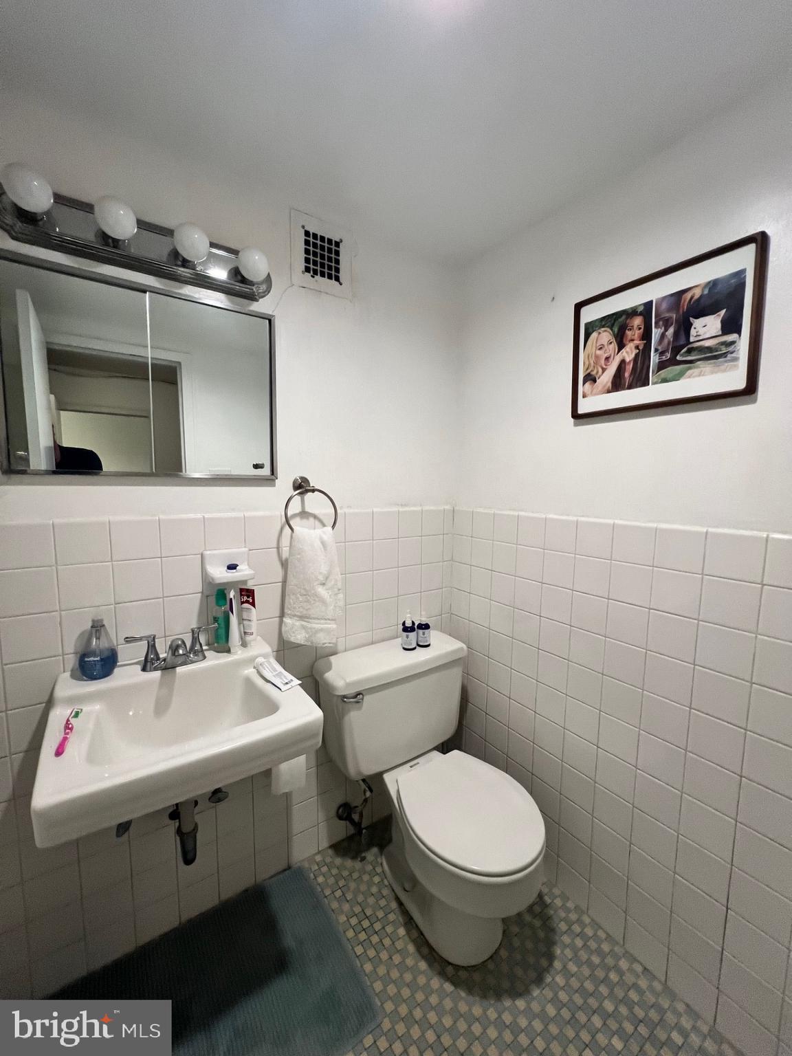 224 West Rittenhouse Square, Unit 1202 Philadelphia, PA 19103 - Photo 5 of 17 a bathroom with a sink mirror and toilet