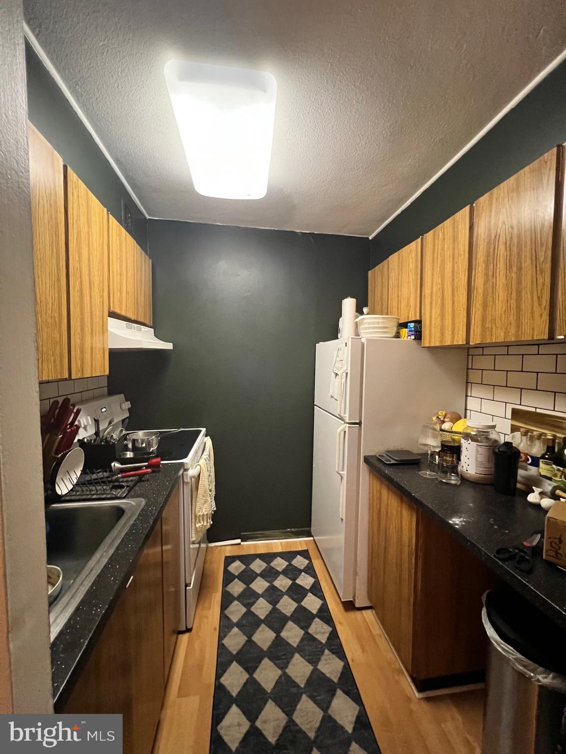 224 West Rittenhouse Square, Unit 1202 Philadelphia, PA 19103 - Photo 9 of 17 a kitchen with a sink a stove and refrigerator