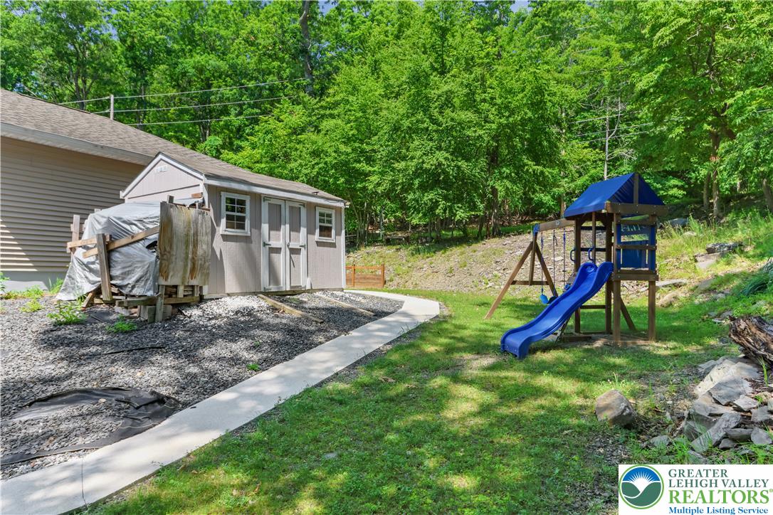 1007 Hampstead Road Bushkill, PA 18324 - Photo 49 of 72 A quaint backyard with a playful swing set, perfect for outdoor fun, nestled beside a practical storage shed.