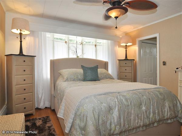 127 Fish Road Tiverton, RI 02878 - Photo 16 of 30 a bedroom with a bed and a chandelier