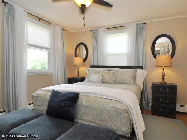 127 Fish Road Tiverton, RI 02878 - Photo 17 of 30 a bedroom with a bed and a chandelier