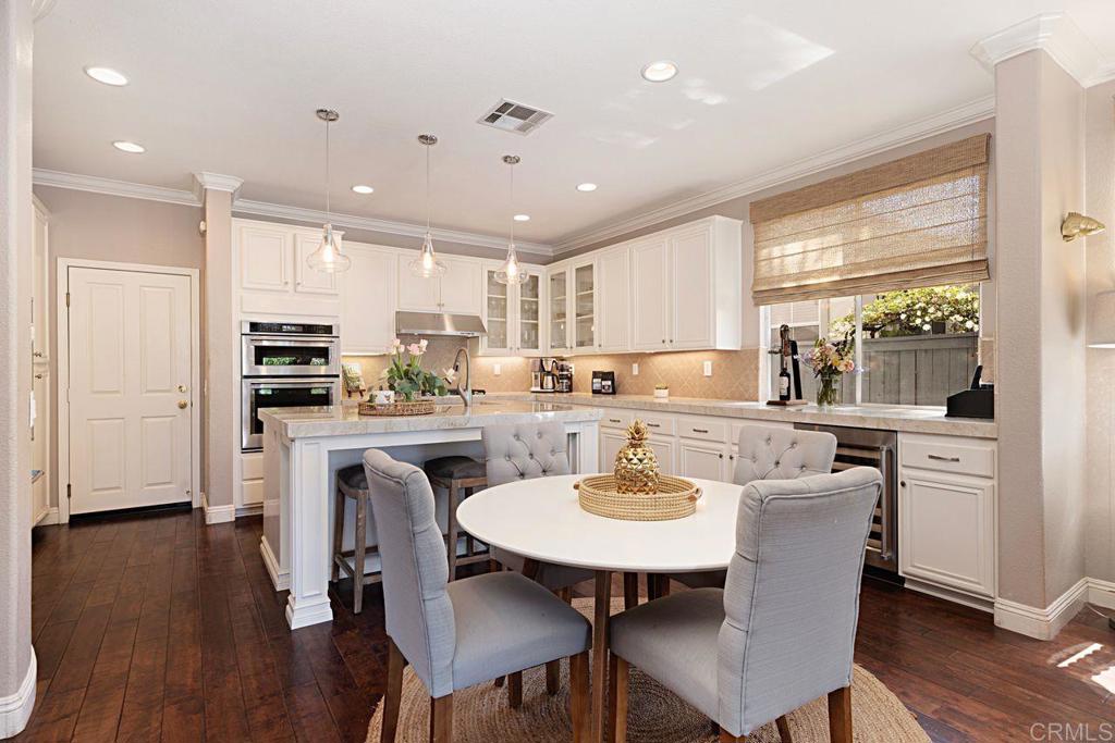 1672 Sagewood Way San Marcos, CA 92078 - Photo 18 of 61 a kitchen with a dining table chairs stainless steel appliances and cabinets