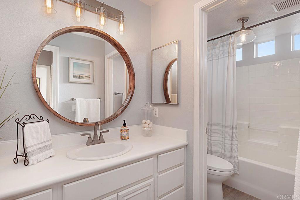 1672 Sagewood Way San Marcos, CA 92078 - Photo 23 of 61 a bathroom with a toilet a sink and mirror