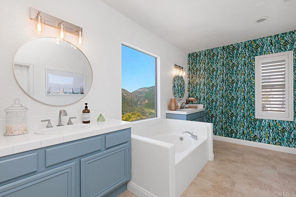 1672 Sagewood Way San Marcos, CA 92078 - Photo 31 of 61 a en suite bathroom with a double vanity sink a mirror and a bathtub