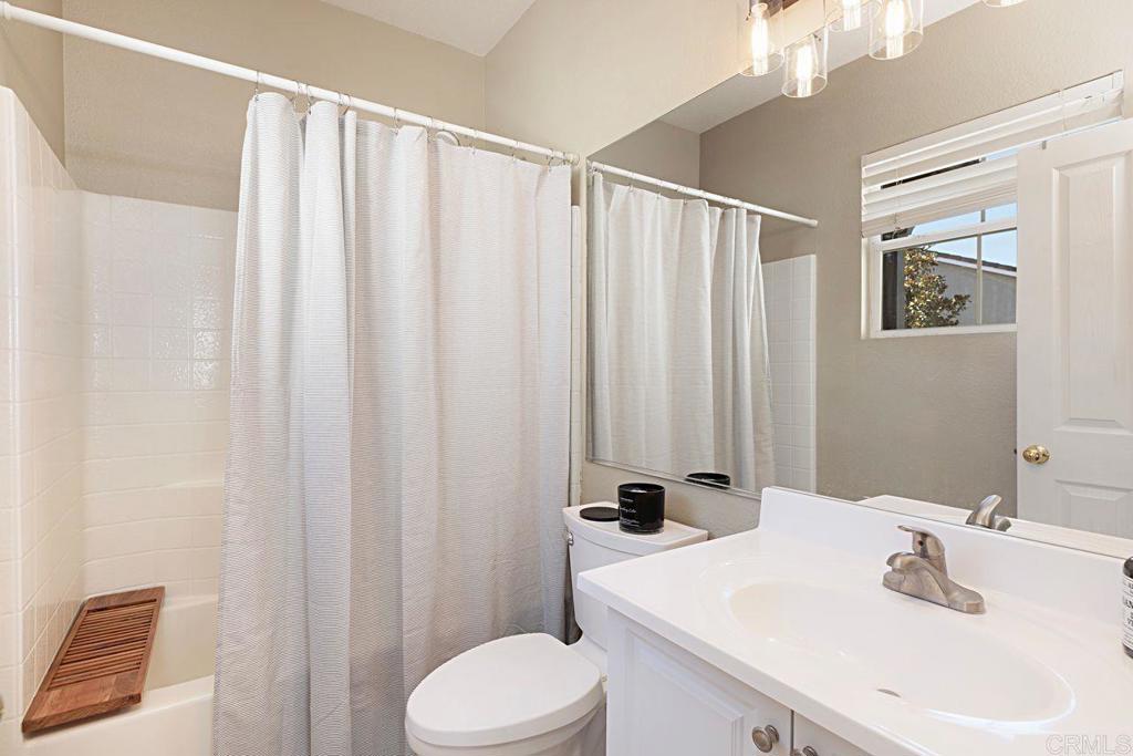 1672 Sagewood Way San Marcos, CA 92078 - Photo 38 of 61 a bathroom with a sink a toilet and shower curtain