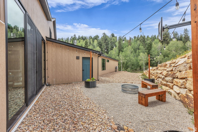 1766 West Tollgate Cyn Road Coalville, UT 84017 - Photo 45 of 59 Gravel patio featuring a stone retaining wall and string lighting
