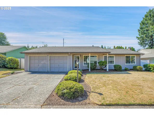 a view of a house with a yard and potted plants