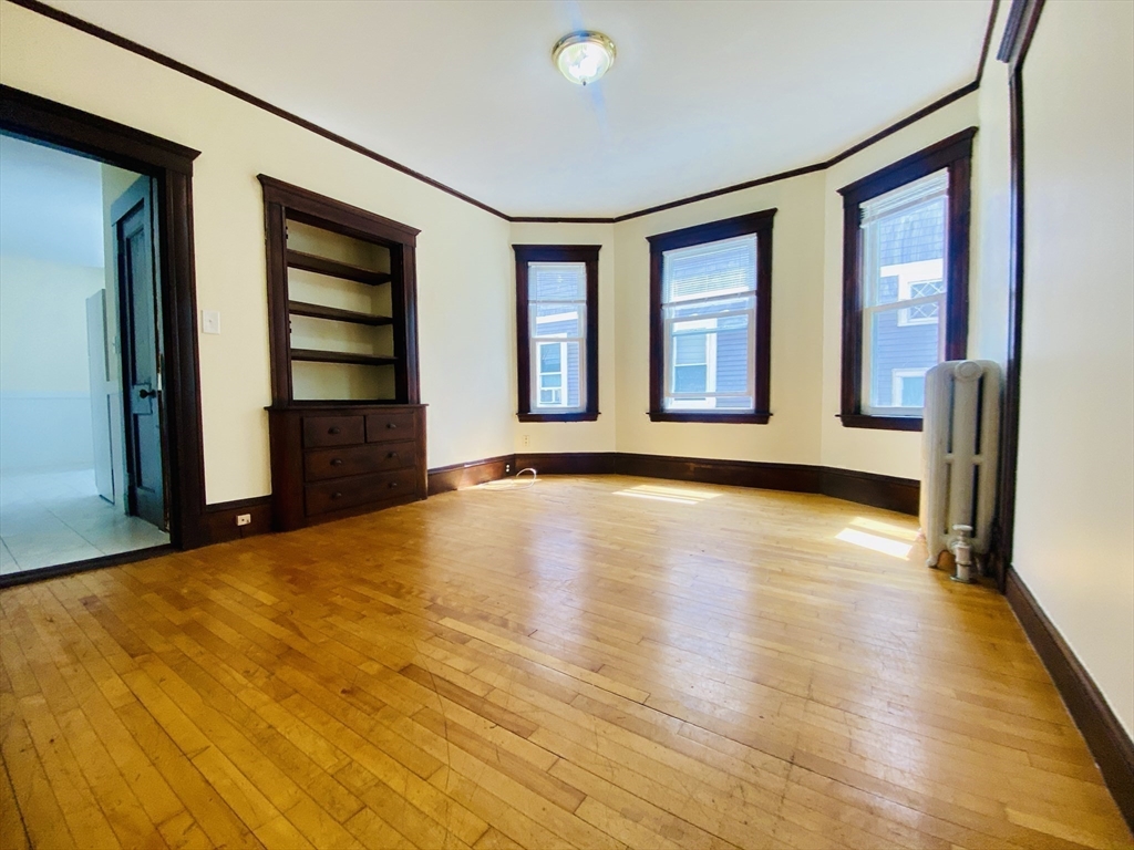 39-41 Michigan Avenue, Unit 1 Somerville, MA 02145 - Photo 22 of 27 a view of an empty room with window and wooden floor