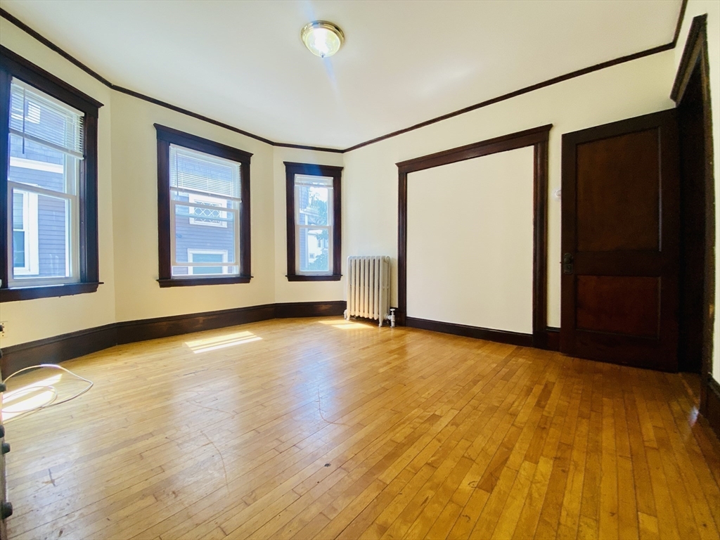 39-41 Michigan Avenue, Unit 1 Somerville, MA 02145 - Photo 24 of 27 a view of an empty room with glass door and wooden floor