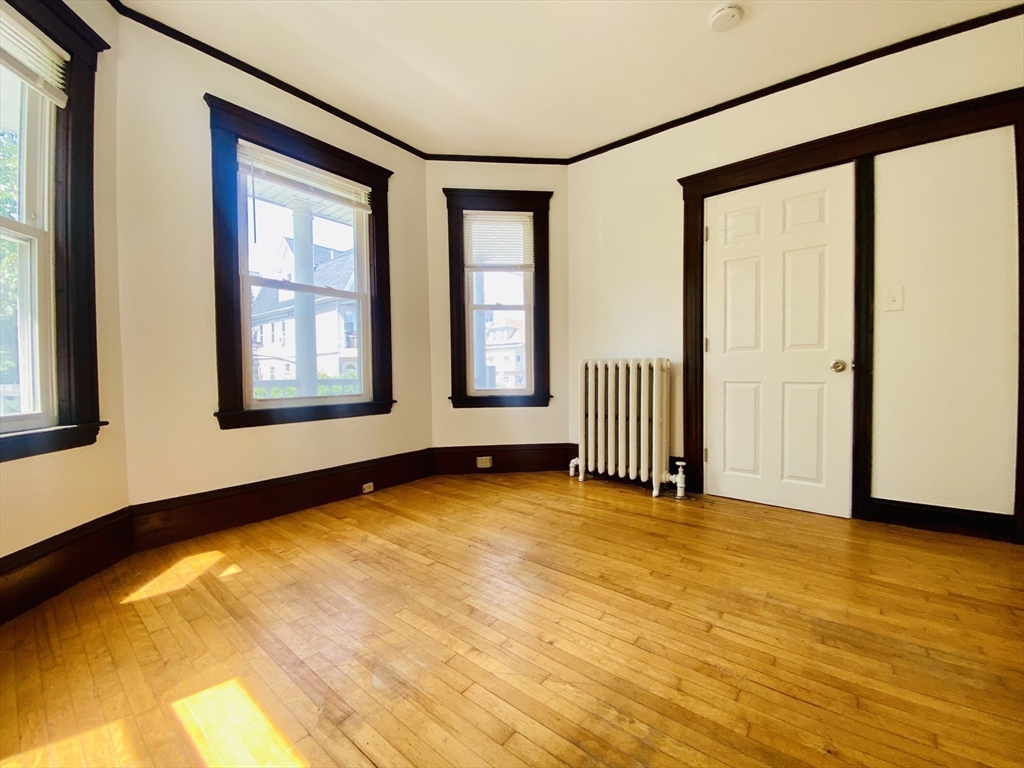 39-41 Michigan Avenue, Unit 1 Somerville, MA 02145 - Photo 9 of 27 a view of an empty room with a window and wooden floor