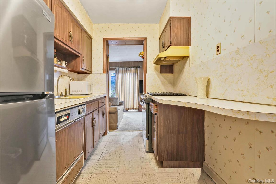 84-92 Austin Street Queens, NY 11415 - Photo 11 of 40 a kitchen with stainless steel appliances granite countertop a sink and a stove