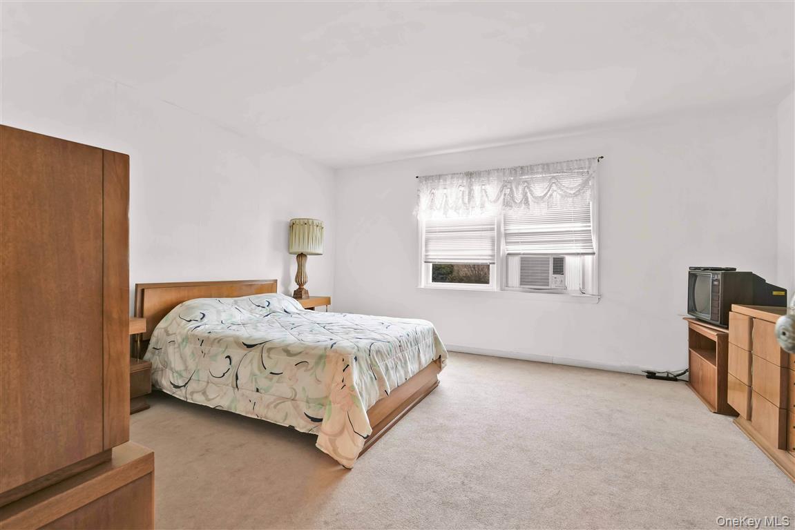 84-92 Austin Street Queens, NY 11415 - Photo 15 of 40 a bedroom with a bed wooden floor and window