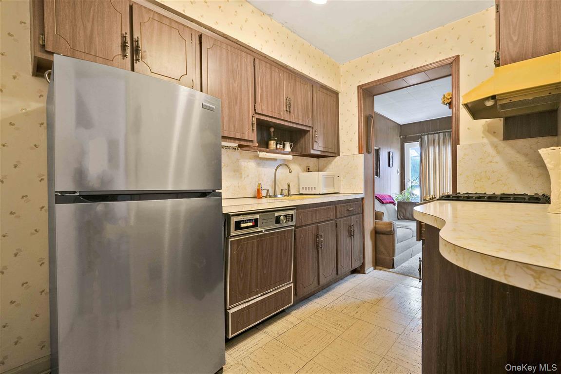 84-92 Austin Street Queens, NY 11415 - Photo 10 of 40 a kitchen with stainless steel appliances granite countertop a refrigerator a stove a sink and a microwave