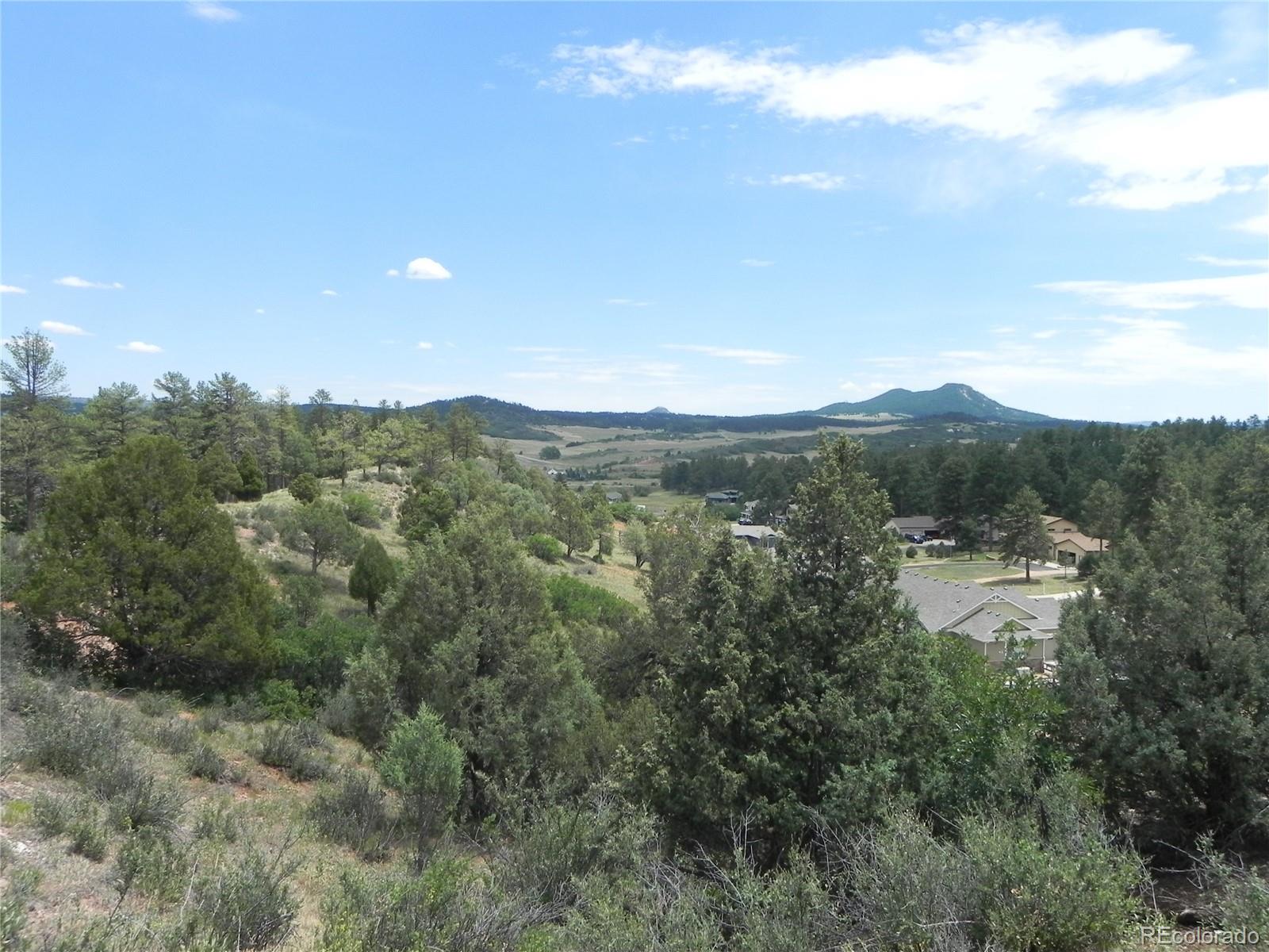 7749 Inca Road Larkspur, CO 80118 - Photo 24 of 49 a view of a town with mountains in the background