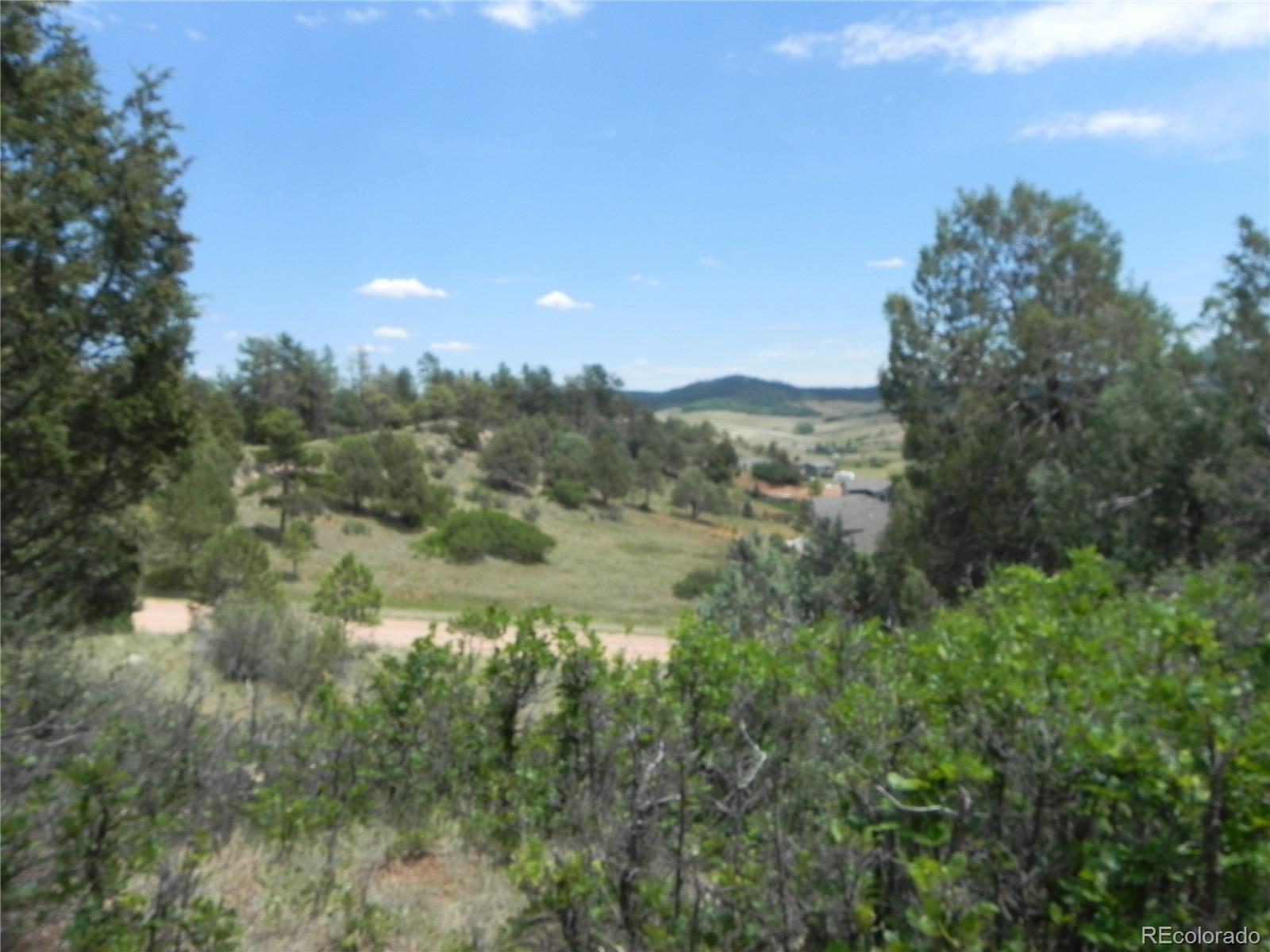 7749 Inca Road Larkspur, CO 80118 - Photo 31 of 49 a view of a lake with a mountain in the background