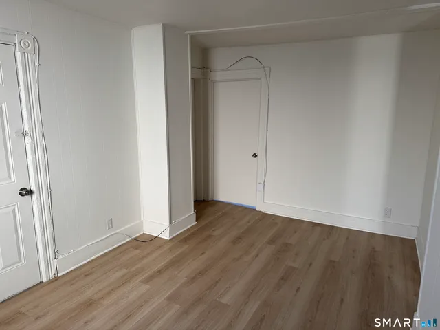 a view of an empty room with wooden floor