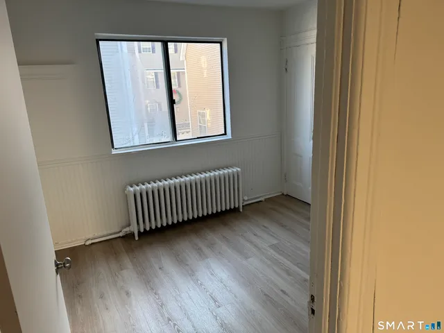a view of a room with wooden floor and a window