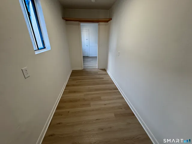 a view of a hallway with wooden floor and entryway
