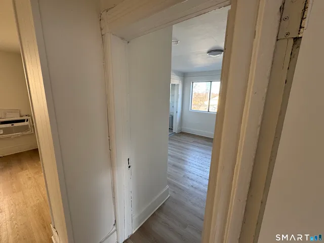 a view of a hallway with wooden floor