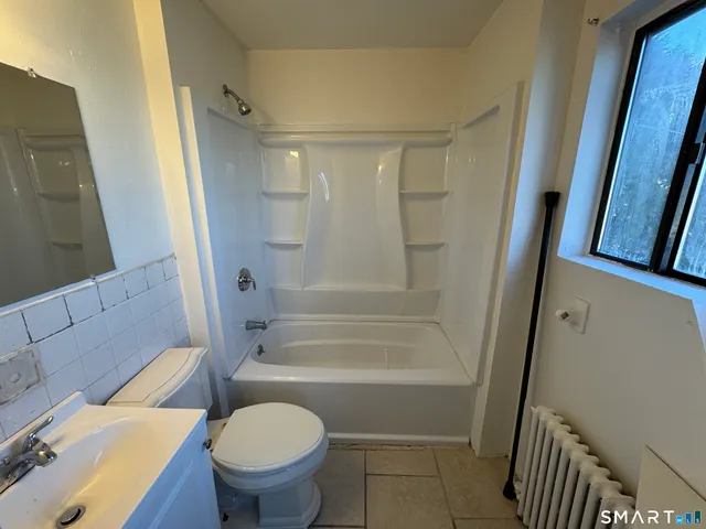 a bathroom with a granite countertop toilet a sink and a mirror