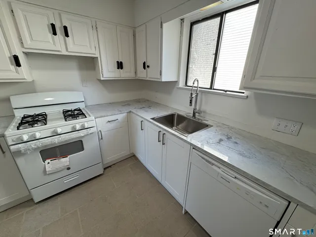 a kitchen with white cabinets and white appliances
