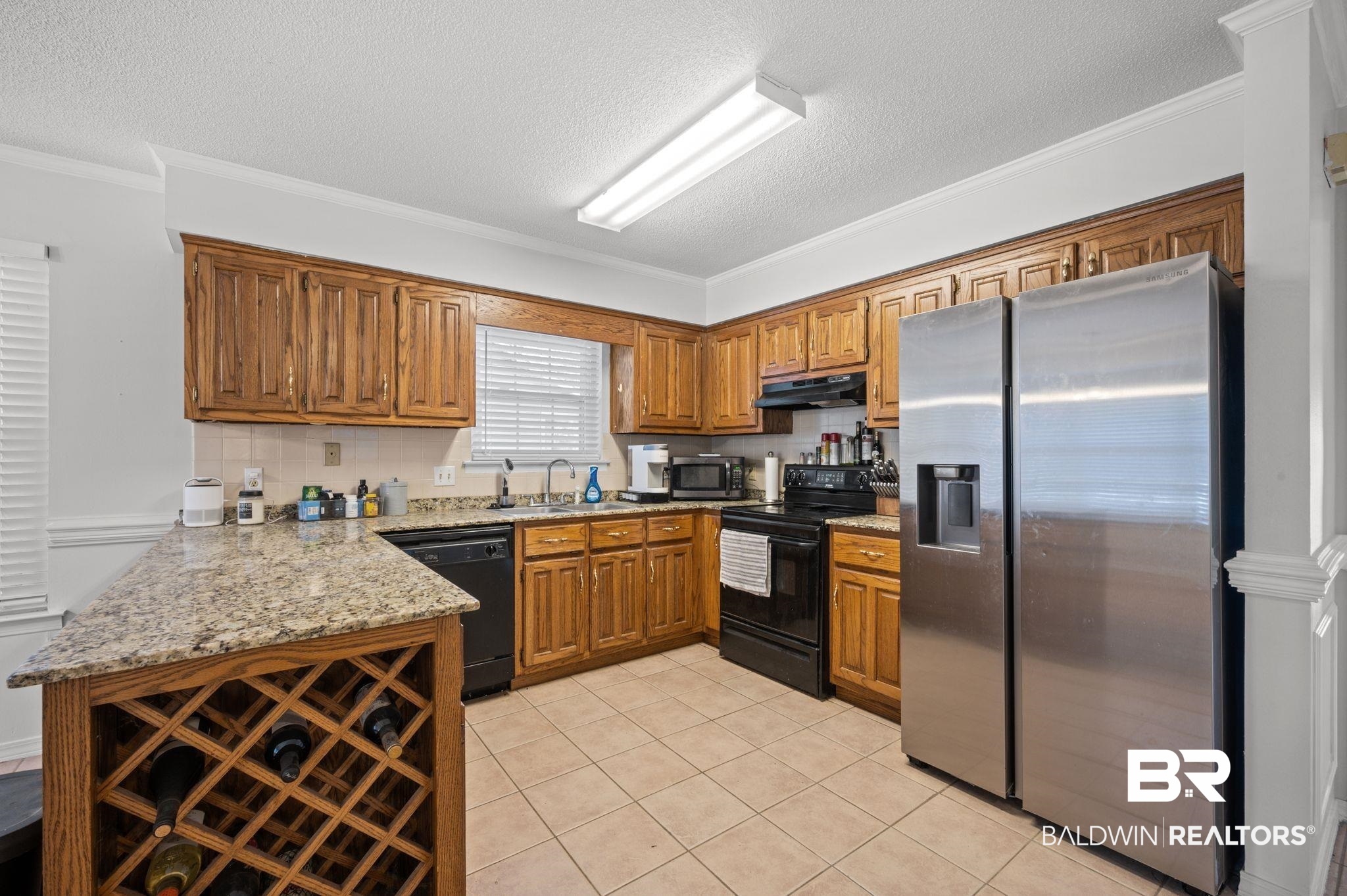 6705 Autumn Ridge Drive Mobile, AL 36695 - Photo 13 of 24 Kitchen with kitchen peninsula, ornamental molding, sink, black appliances, and light tile patterned floors