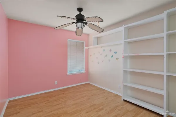 a view of empty room with a window and ceiling fan